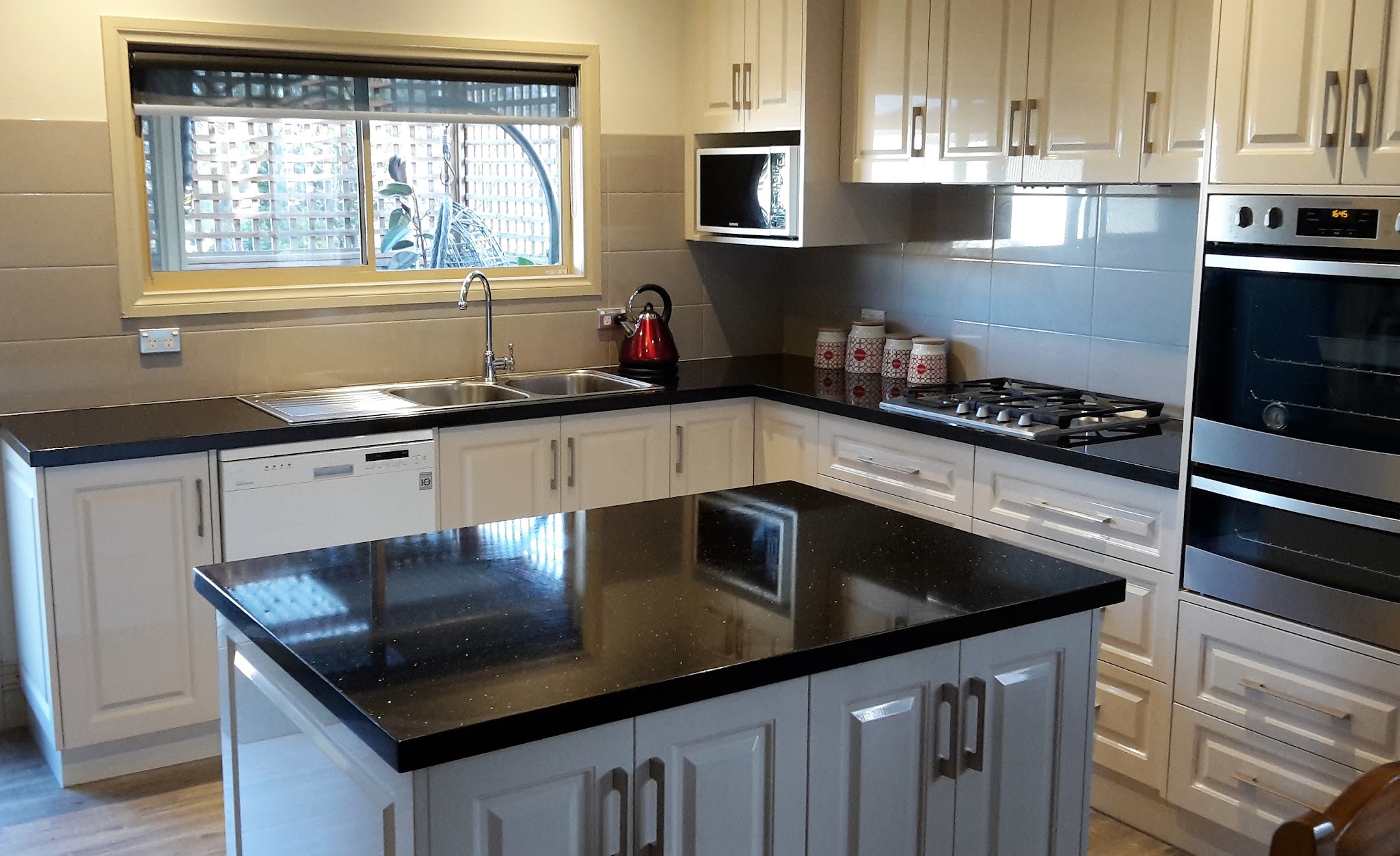 Classic profiled cream kitchen with black speckled stone bench tops
